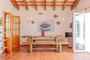 a room with a wooden table and a bench at Racó Blau in Cap d'en Font