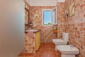 a bathroom with two toilets and a sink and a window at Racó Blau in Cap d'en Font +20 photos