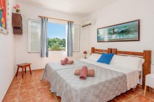 a bedroom with two beds and a window at Racó Blau in Cap d'en Font