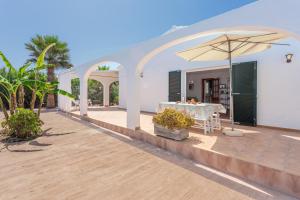 a patio with a table and an umbrella at Racó Blau in Cap d'en Font