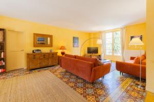 a living room with two couches and a television at Maison Vigneronne-piscine et vignes in Trèbes