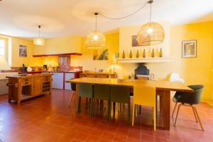 a kitchen with a large wooden table and chairs at Maison Vigneronne-piscine et vignes in Trèbes