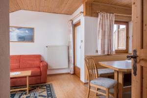 a living room with a couch and a table at Gamperhof Apartment Latemar in Collepietra +21 photos