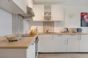 a kitchen with white cabinets and a wooden counter top at Ferienwohnung Griaß di in Salgen