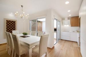a kitchen and dining room with a white table and chairs at Casa do Marquês in Vila Real de Santo António