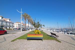 a colorful bench sitting on a sidewalk near a marina at Casa do Marquês in Vila Real de Santo António