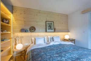 a bedroom with a bed with a wooden wall at Haus Alpenveilchen - Appartement 3 in Schönau am Königssee