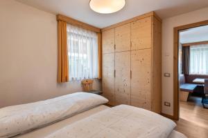 a bedroom with a bed and a large window at Ciasa Rungg Monte Sella Suite in San Vigilio Di Marebbe
