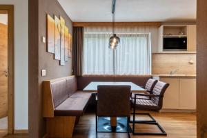 a dining room and kitchen with a table and chairs at Ciasa Rungg Monte Sella Suite in San Vigilio Di Marebbe