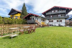 a house with a table and chairs in the yard at Haus Alpenveilchen - Appartement 3 in Schönau am Königssee