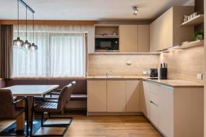 a kitchen with a table and a dining room at Ciasa Rungg Monte Sella Suite in San Vigilio Di Marebbe