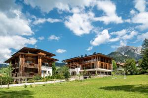 two buildings in a field with a soccer ball at Ciasa Rungg Monte Sella Suite in San Vigilio Di Marebbe