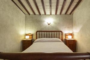 a bedroom with a bed and two night stands with lights at Cal Cisteller in Olvan