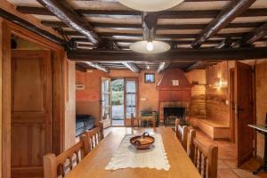 a dining room with a table and chairs and a fireplace at Cal Cisteller in Olvan