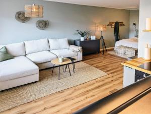 a living room with a white couch and a table at Ferienwohnung Nautilus in Heiligenhafen