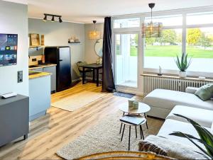 a living room with a white couch and a kitchen at Ferienwohnung Nautilus in Heiligenhafen