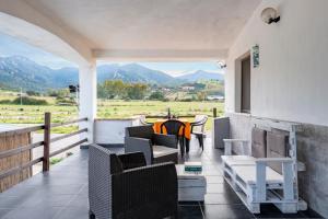 a porch with chairs and a table with a view of mountains at Casa I Ginepri in Cardedu
