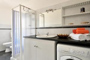 a bathroom with a sink and a washing machine at Casa I Ginepri in Cardedu +17 photos