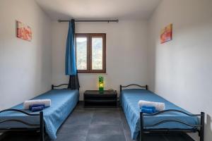 two twin beds in a room with a window at Casa I Ginepri in Cardedu