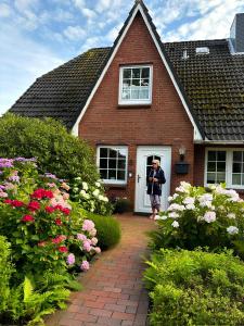 a person taking a picture of a house at Ferienwohnung Ackerkoog in Niebüll