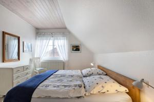 a bedroom with a bed and a dresser and a window at Ferienwohnung Ackerkoog in Niebüll