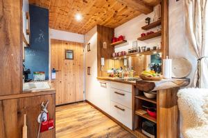 a kitchen in a tiny house with wood paneling at Chalet Hüttentraum in Inzell +15 photos