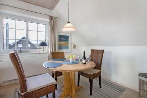 a dining room with a wooden table and chairs at Ferienwohnung Ackerkoog in Niebüll
