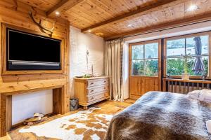 a bedroom with a large bed and a flat screen tv at Chalet Hüttentraum in Inzell