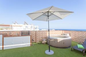 an umbrella and a hot tub on a roof at Apartamento San Juan 18 in Nerja