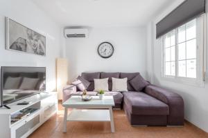 a living room with a purple couch and a table at Apartamento San Juan 18 in Nerja