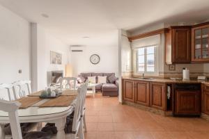 a kitchen and living room with a table and a couch at Apartamento San Juan 18 in Nerja +14 photos