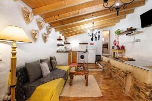 a living room with a couch and a kitchen at Quinta do Silêncio T2 in Tavira