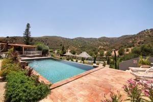 a swimming pool in a yard with mountains in the background at Quinta do Silêncio T2 in Tavira