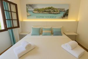 a bedroom with a large white bed with two pillows at Magda - Cala En Porter in Cala en Porter