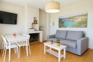 a living room with a couch and a table at Magda - Cala En Porter in Cala en Porter