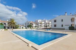 a large swimming pool in the middle of a villa at Magda - Cala En Porter in Cala en Porter