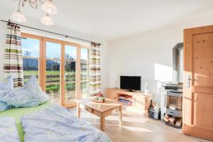 a bedroom with a bed and a tv and a table at Ferienwohnung Bergblick in Bad Heilbrunn