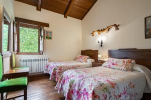 ein Schlafzimmer mit zwei Betten und einem Fenster in der Unterkunft Maseda 2 in Villayón