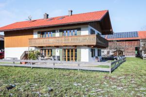 a large house with a red roof and a yard at Ferienwohnung Bergblick in Bad Heilbrunn