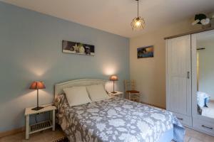 a bedroom with a bed and two tables and two lamps at La maison de vacances Mathieu in Artigues