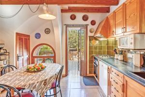 a kitchen with a table with a bowl of fruit on it at Ca les Estamenyes in Pollença