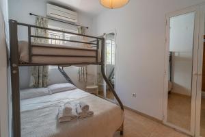 a bedroom with a bunk bed with two pairs of slippers at Bravo spectacular views in Viñuela +32 photos