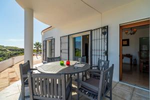 a table and chairs on a patio with a view of the ocean at Bravo spectacular views in Viñuela