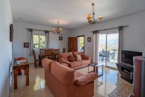 a living room with a couch and a television at Bravo spectacular views in Viñuela
