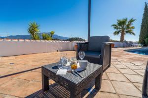 a table with wine glasses and a chair on a patio at Bravo spectacular views in Viñuela