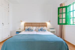 a bedroom with a blue and white bed with two pillows at Bungalow Alma Ocean View in Puerto del Carmen +13 photos
