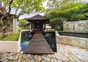 a pool with a wooden walkway leading to a house at MUTHI MAYA Forest Pool Villa Resort - SHA Plus Certified in Mu Si