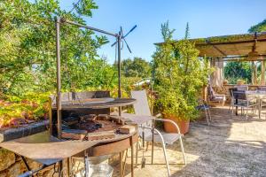 an outdoor patio with a grill and tables and chairs at Ca les Estamenyes in Pollença