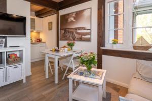 a living room with two tables and a kitchen at Ferienwohnung Strandgut in Pellworm