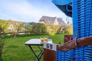 two glasses of beer sitting on a table in a yard at Ferienwohnung Strandgut in Pellworm